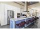 Modern kitchen features a large island with seating, stainless steel appliances, and ample counter space at 1539 Corolla Ct, Reunion, FL 34747
