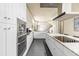 Contemporary kitchen with sleek countertops, white cabinetry, and stainless steel appliances at 1539 Corolla Ct, Reunion, FL 34747