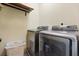 Functional laundry room with updated appliances and additional overhead storage at 1539 Corolla Ct, Reunion, FL 34747