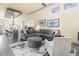 Bright living room with large gray sectional sofa, ottoman, patterned rug, and view into kitchen at 1539 Corolla Ct, Reunion, FL 34747