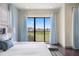Bright main bedroom featuring a king-size bed and balcony overlooking a golf course at 1539 Corolla Ct, Reunion, FL 34747