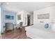 Spacious main bedroom featuring hardwood floors, seating area, and view to the ensuite bathroom at 1539 Corolla Ct, Reunion, FL 34747