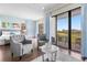 Main bedroom featuring hardwood floors, stylish furnishings, and balcony access with scenic golf course views at 1539 Corolla Ct, Reunion, FL 34747
