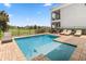 A beautiful backyard pool features a sun shelf with lounge chairs and views of the golf course at 1539 Corolla Ct, Reunion, FL 34747
