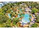 Aerial view of the resort's fantastic water park, featuring lazy rivers, pools, palm trees, and lounge areas at 1539 Corolla Ct, Reunion, FL 34747