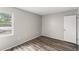 Simple bedroom with wood-look floors, white walls, and a window for a bright, minimalist design at 1550 11Th Ne St # H-4, Winter Haven, FL 33881