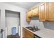 Kitchen featuring stainless steel appliances, wood cabinets, and a dedicated laundry nook at 1550 11Th Ne St # H-4, Winter Haven, FL 33881
