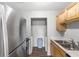 Kitchen featuring stainless steel appliances, wood cabinets, and a dedicated laundry nook at 1550 11Th Ne St # H-4, Winter Haven, FL 33881