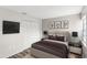 The main bedroom features a neutral palette, a modern ceiling fan, closet, and tv at 1550 11Th Ne St # H-4, Winter Haven, FL 33881