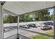 View of parking and greenery through a screened-in porch at 1550 11Th Ne St # H-4, Winter Haven, FL 33881