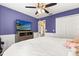 Purple bedroom with television, ceiling fan, closet space and neutral wood-look floors at 1563 Dess Dr, Orlando, FL 32818