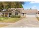 Charming single-story home with a well-manicured lawn, attached two-car garage, and a welcoming front porch at 1563 Dess Dr, Orlando, FL 32818