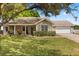 Charming single-story home with a well-manicured lawn, cozy front porch, and attached two car garage at 1563 Dess Dr, Orlando, FL 32818