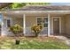 Inviting front porch with white railings and colorful foliage flanking the front door at 1563 Dess Dr, Orlando, FL 32818