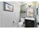 A cute half-bath with grey and green walls, modern fixtures and stylish decor at 1682 Wingspan Way, Winter Springs, FL 32708