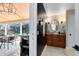 Powder room with stone countertop is adjacent to an outdoor dining area and pool creating an entertainer's paradise at 1682 Wingspan Way, Winter Springs, FL 32708
