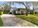Beautiful home featuring a large driveway, green grass, professional landscaping and mature trees at 1682 Wingspan Way, Winter Springs, FL 32708