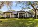 Stunning single-story home featuring mature trees, lush landscaping, and a well-manicured lawn at 1682 Wingspan Way, Winter Springs, FL 32708