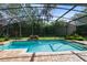 Sparkling pool with waterfall and lush landscaping within a screened enclosure creates the ultimate backyard oasis at 1682 Wingspan Way, Winter Springs, FL 32708