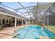 Large pool with waterfall feature is surrounded by a screened enclosure, creating the perfect backyard retreat at 1682 Wingspan Way, Winter Springs, FL 32708