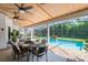 Enclosed patio features a sparkling pool, outdoor dining area, and lush landscaping creating a private backyard oasis at 1682 Wingspan Way, Winter Springs, FL 32708