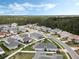 Scenic aerial perspective of a modern residential development surrounded by lush green forests under a blue sky at 16936 Champlain St, Clermont, FL 34714