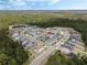 Wide aerial view of a planned community with homes nestled among lush greenery and a small pond at 16936 Champlain St, Clermont, FL 34714