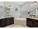 Elegant bathroom featuring dual vanities, a large soaking tub, and neutral tile flooring at 16936 Champlain St, Clermont, FL 34714