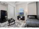Cozy bedroom featuring a bed and rocking chair complemented by a TV and arched window at 16936 Champlain St, Clermont, FL 34714