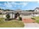 Attractive single-story home with manicured lawn, brick driveway, and neutral exterior paint at 16936 Champlain St, Clermont, FL 34714
