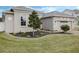 Well-manicured lawn features a mulched garden bed and a young tree at 16936 Champlain St, Clermont, FL 34714