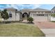 Beautiful home featuring a manicured lawn, landscaped garden beds, and a brick paver driveway at 16936 Champlain St, Clermont, FL 34714