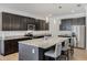 Gourmet kitchen boasts dark wood cabinetry, stainless appliances, granite counters, and an oversized island with seating at 16936 Champlain St, Clermont, FL 34714
