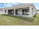 Covered patio overlooking a well-maintained lawn, sliding glass doors, and outdoor seating at 16936 Champlain St, Clermont, FL 34714