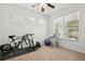 Bright bedroom features a ceiling fan, neutral carpet, and large window at 1825 Saffron Plum Ln, Orlando, FL 32828
