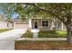 Charming beige two-story home featuring a cozy front porch and attached two-car garage at 1825 Saffron Plum Ln, Orlando, FL 32828