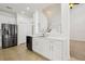 Open kitchen with stainless steel appliances, white cabinets, and a view to the staircase at 1825 Saffron Plum Ln, Orlando, FL 32828