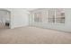 Bright, open living room with neutral carpet and large windows at 1825 Saffron Plum Ln, Orlando, FL 32828
