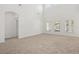 Empty living room featuring neutral carpet, white walls, and bright windows at 1825 Saffron Plum Ln, Orlando, FL 32828
