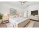 The light-filled main bedroom features a ceiling fan and luxurious gold and white decor at 1825 Saffron Plum Ln, Orlando, FL 32828