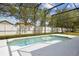 A view of the pool and backyard, enclosed with screen, surrounded by tropical trees at 1825 Saffron Plum Ln, Orlando, FL 32828