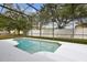 A view of the pool and backyard, enclosed with screen, surrounded by tropical trees at 1825 Saffron Plum Ln, Orlando, FL 32828