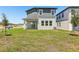 The backyard features a covered patio, lush green grass and partial view of the home's exterior at 1912 Archer Dr, Minneola, FL 34715