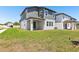 The backyard features a covered patio, lush green grass and partial view of the home's exterior at 1912 Archer Dr, Minneola, FL 34715