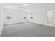 Bright bedroom featuring plush carpeting, neutral walls, and three large windows at 1912 Archer Dr, Minneola, FL 34715