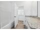 Bright bathroom with granite vanity top, tile flooring, and open doorway to shower at 2236 Hen Rd, Minneola, FL 34715