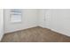 Neutral bedroom featuring carpet, door, and a window with natural light at 2236 Hen Rd, Minneola, FL 34715