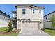Charming two-story home with a neatly paved driveway and attached two-car garage, exuding modern curb appeal at 2236 Hen Rd, Minneola, FL 34715