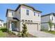 Charming two-story home with a paved driveway, attached two-car garage, and inviting blue front door at 2236 Hen Rd, Minneola, FL 34715