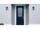 Close-up view of a dark front door framed by elegant sconces and white trim at 2252 Emerald Springs Dr, Apopka, FL 32712